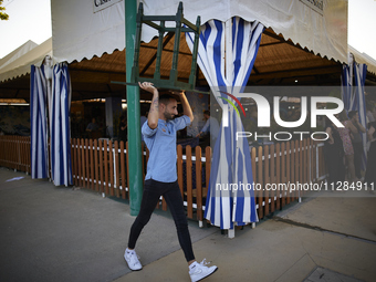 A waiter is carrying a table outside the ''caseta'' during the festivities of the Corpus Christi in Granada, Spain, on May 28, 2024. The Cor...