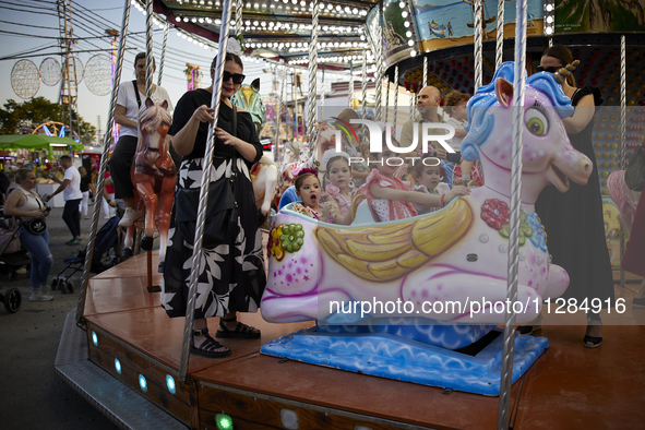 Children are riding a swing at the fairgrounds during the festivities of the Corpus Christi in Granada, Spain, on May 28, 2024. The Corpus C...