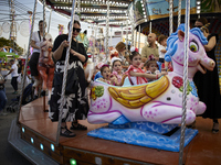 Children are riding a swing at the fairgrounds during the festivities of the Corpus Christi in Granada, Spain, on May 28, 2024. The Corpus C...