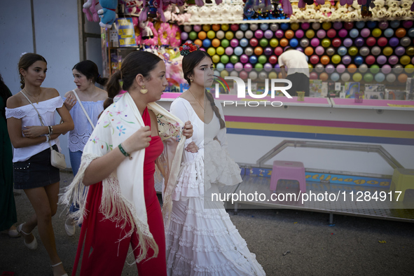 Two girls are wearing traditional flamenco dresses and walking during the festivities of the Corpus Christi in Granada, Spain, on May 28, 20...