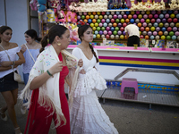 Two girls are wearing traditional flamenco dresses and walking during the festivities of the Corpus Christi in Granada, Spain, on May 28, 20...