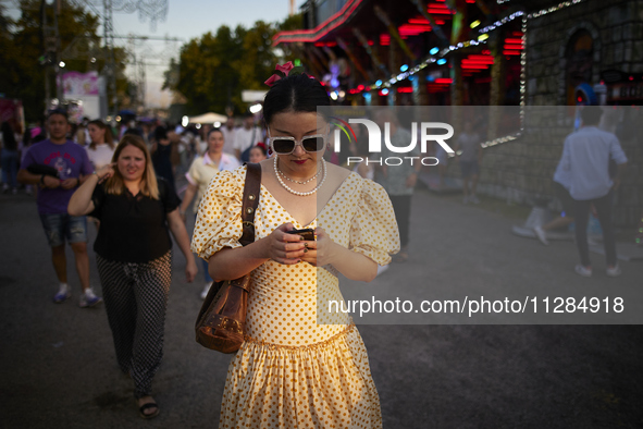 A woman dressed in a typical flamenco dress is checking her cell phone during the festivities of the Corpus Christi in Granada, Spain, on Ma...