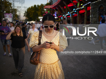 A woman dressed in a typical flamenco dress is checking her cell phone during the festivities of the Corpus Christi in Granada, Spain, on Ma...