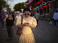 A woman dressed in a typical flamenco dress is checking her cell phone during the festivities of the Corpus Christi in Granada, Spain, on Ma...