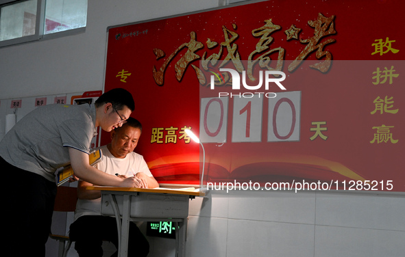 A senior three student is asking her teacher a question at the door of her classroom at Fengfeng No 1 Middle School in Handan, Hebei provinc...