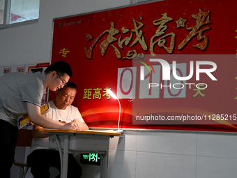 A senior three student is asking her teacher a question at the door of her classroom at Fengfeng No 1 Middle School in Handan, Hebei provinc...