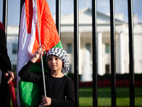 A young girl holds a Palestinian flag in front of the White House where she is taking part in a protest against the Israeli attacks on civil...