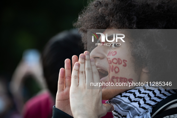 A man with face paint chants with hundreds of people protesting in front of the White House against the Israeli attacks on civilians in Rafa...