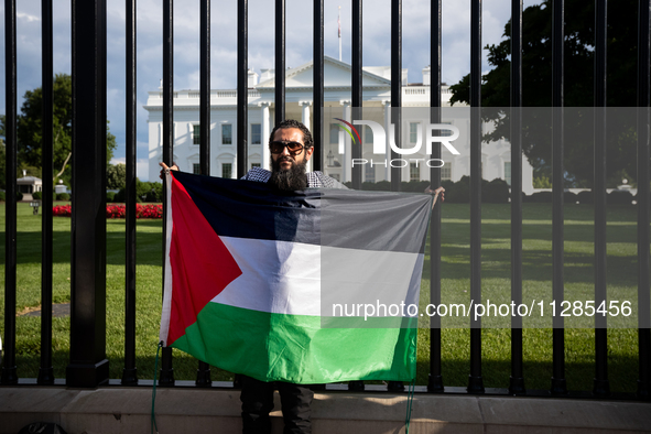 A man displays a Palestinian flag in front of the White House during a protest against the Israeli attacks on civilians in Rafah that have k...