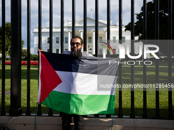 A man displays a Palestinian flag in front of the White House during a protest against the Israeli attacks on civilians in Rafah that have k...