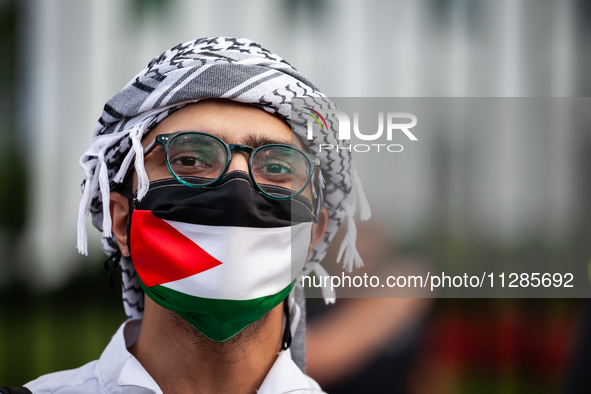 A demonstrator in a keffiyeh and Palestinian flag participates in a protest at the White House against the Israeli attacks on civilians in R...