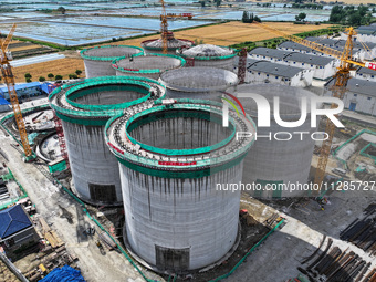 Workers are working at the construction site of a grain storage project of the Yandu branch of the Central Grain Reserve Yancheng Direct War...