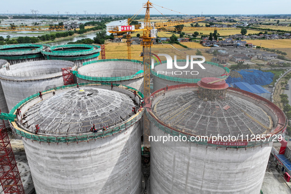 Workers are working at the construction site of a grain storage project of the Yandu branch of the Central Grain Reserve Yancheng Direct War...