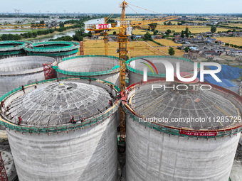 Workers are working at the construction site of a grain storage project of the Yandu branch of the Central Grain Reserve Yancheng Direct War...