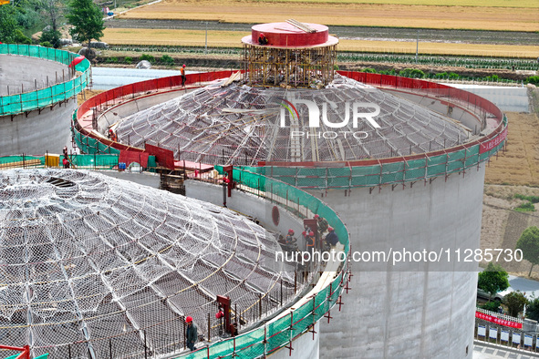 Workers are working at the construction site of a grain storage project of the Yandu branch of the Central Grain Reserve Yancheng Direct War...