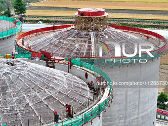 Workers are working at the construction site of a grain storage project of the Yandu branch of the Central Grain Reserve Yancheng Direct War...