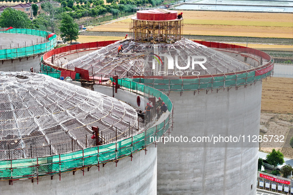 Workers are working at the construction site of a grain storage project of the Yandu branch of the Central Grain Reserve Yancheng Direct War...