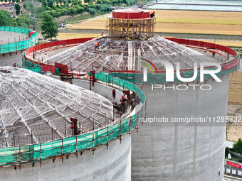 Workers are working at the construction site of a grain storage project of the Yandu branch of the Central Grain Reserve Yancheng Direct War...