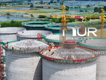 Workers are working at the construction site of a grain storage project of the Yandu branch of the Central Grain Reserve Yancheng Direct War...