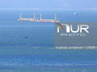 Fishermen are driving a breeding boat to carry out ecological farming work on the sea surface at a Marine ranch in Dinghai Bay in Fuzhou, Fu...