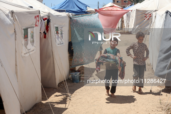 Displaced Palestinians are being seen among the tents in Deir el-Balah in the central Gaza Strip on May 29, 2024, amid the ongoing conflict...