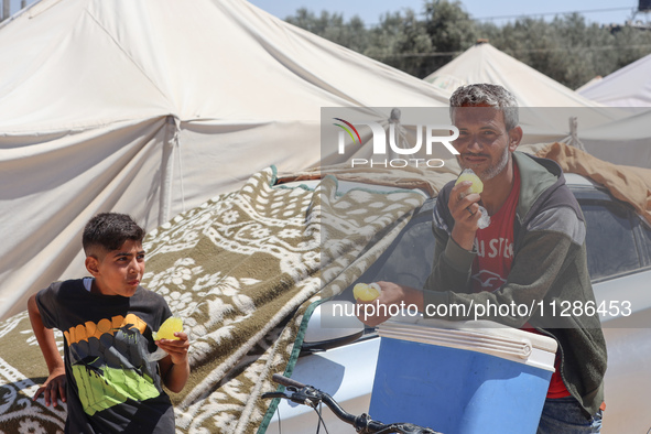 A vendor is selling ice cream at a camp for displaced Palestinians in Deir el-Balah in the central Gaza Strip on May 29, 2024, amid the ongo...