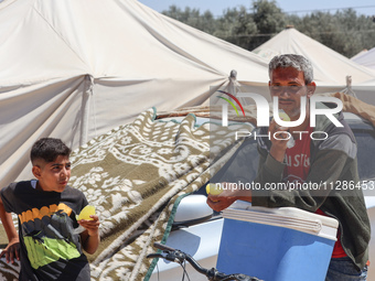 A vendor is selling ice cream at a camp for displaced Palestinians in Deir el-Balah in the central Gaza Strip on May 29, 2024, amid the ongo...