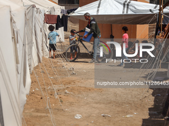 A vendor is selling ice cream at a camp for displaced Palestinians in Deir el-Balah in the central Gaza Strip on May 29, 2024, amid the ongo...