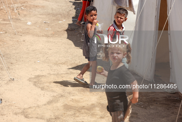 A Palestinian boy is eating ice cream at a camp for displaced Palestinians in Deir el-Balah in the central Gaza Strip on May 29, 2024, amid...