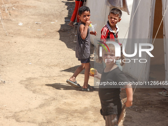 A Palestinian boy is eating ice cream at a camp for displaced Palestinians in Deir el-Balah in the central Gaza Strip on May 29, 2024, amid...