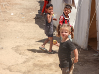 A Palestinian boy is eating ice cream at a camp for displaced Palestinians in Deir el-Balah in the central Gaza Strip on May 29, 2024, amid...