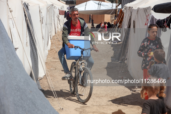 A vendor is selling ice cream at a camp for displaced Palestinians in Deir el-Balah in the central Gaza Strip on May 29, 2024, amid the ongo...