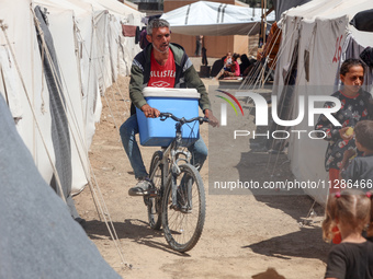 A vendor is selling ice cream at a camp for displaced Palestinians in Deir el-Balah in the central Gaza Strip on May 29, 2024, amid the ongo...