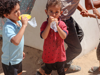 A Palestinian boy is eating ice cream at a camp for displaced Palestinians in Deir el-Balah in the central Gaza Strip on May 29, 2024, amid...