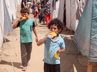 A Palestinian boy is eating ice cream at a camp for displaced Palestinians in Deir el-Balah in the central Gaza Strip on May 29, 2024, amid...