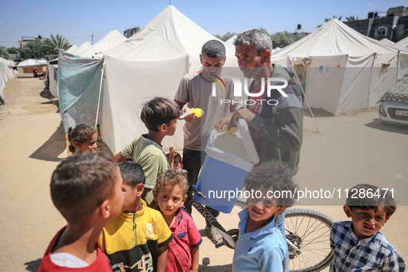 A vendor is selling ice cream at a camp for displaced Palestinians in Deir el-Balah in the central Gaza Strip on May 29, 2024, amid the ongo...