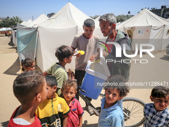 A vendor is selling ice cream at a camp for displaced Palestinians in Deir el-Balah in the central Gaza Strip on May 29, 2024, amid the ongo...