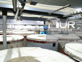 A worker is performing textile work at a textile workshop of a textile company in Aksu prefecture, Northwest China's Xinjiang Uygur autonomo...