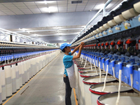 A worker is performing textile work at a textile workshop of a textile company in Aksu prefecture, Northwest China's Xinjiang Uygur autonomo...