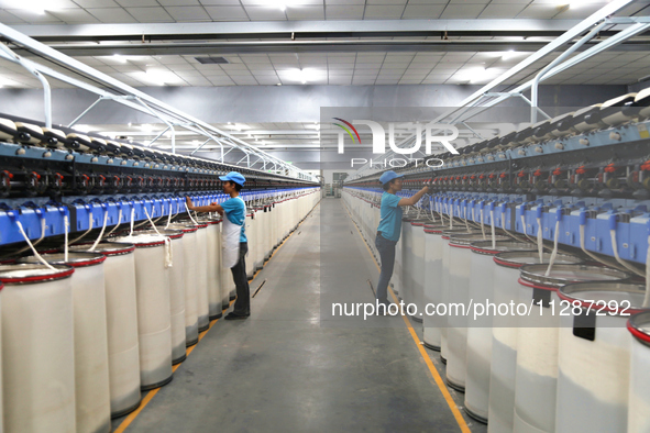 Workers are performing textile work at a textile workshop of a textile company in Aksu prefecture, Northwest China's Xinjiang Uygur autonomo...