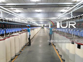 Workers are performing textile work at a textile workshop of a textile company in Aksu prefecture, Northwest China's Xinjiang Uygur autonomo...