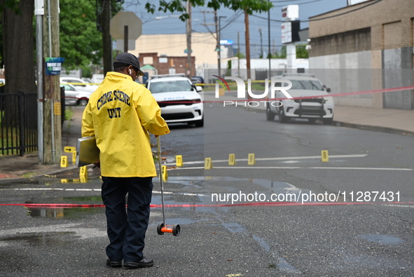 The Philadelphia Police Crime Scene Unit is placing evidence markers at the crime scene and taking photographs of the scene while investigat...