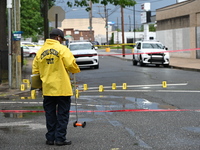 The Philadelphia Police Crime Scene Unit is placing evidence markers at the crime scene and taking photographs of the scene while investigat...