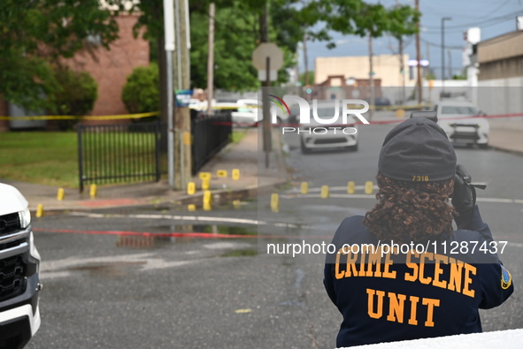 The Philadelphia Police Crime Scene Unit is placing evidence markers at the crime scene and taking photographs of the scene while investigat...