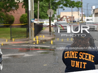 The Philadelphia Police Crime Scene Unit is placing evidence markers at the crime scene and taking photographs of the scene while investigat...