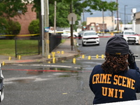 The Philadelphia Police Crime Scene Unit is placing evidence markers at the crime scene and taking photographs of the scene while investigat...