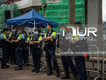 Police officers are standing outside the courthouse to hear the verdict of the trial of the 47 pro-democracy figures in Hong Kong, China, on...