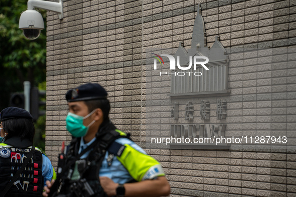 A police officer is standing guard at the courthouse where the verdict of the trial of the 47 pro-democracy figures is being handed out in H...