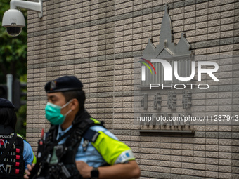 A police officer is standing guard at the courthouse where the verdict of the trial of the 47 pro-democracy figures is being handed out in H...