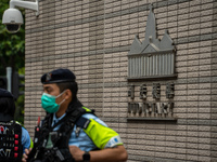 A police officer is standing guard at the courthouse where the verdict of the trial of the 47 pro-democracy figures is being handed out in H...